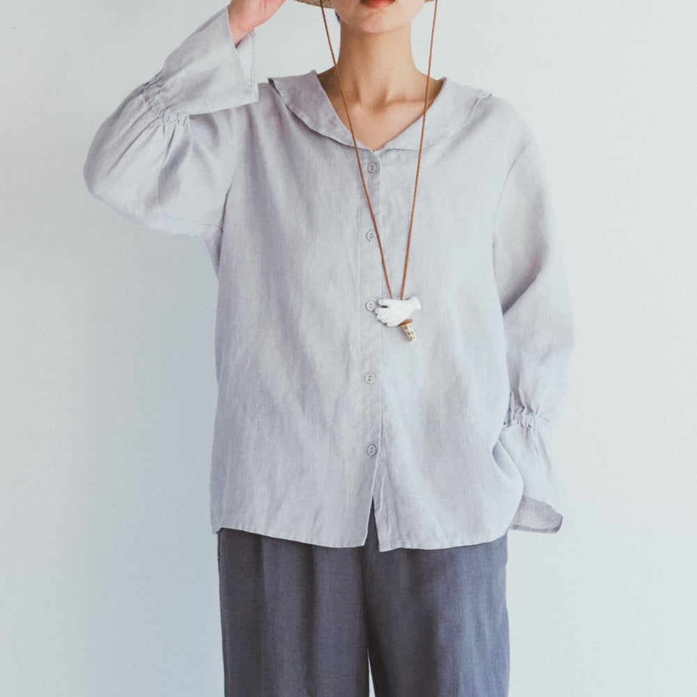 Person wearing a light gray shirt, blue pants, and a straw hat on a white background
