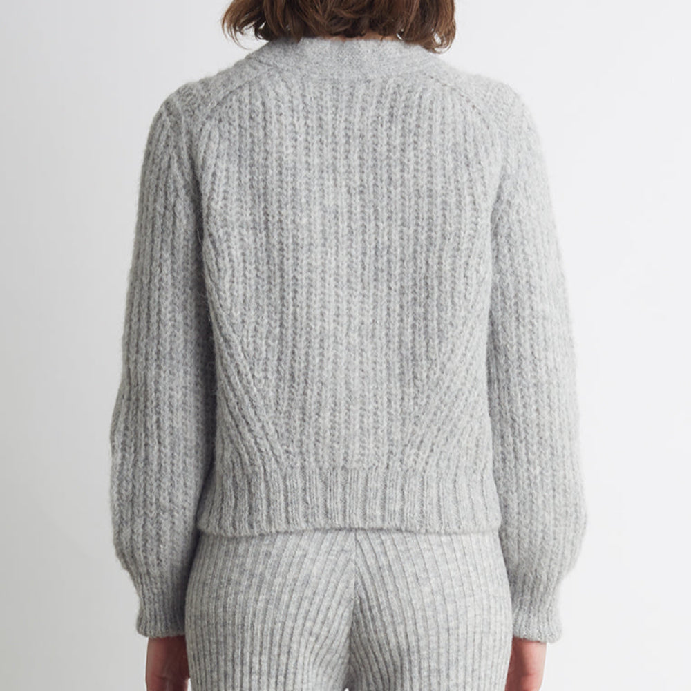 Person wearing a gray ribbed knit outfit on a white background