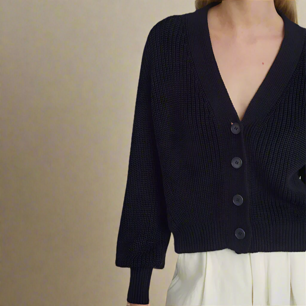 Navy blue cardigan worn by a person on a light background
