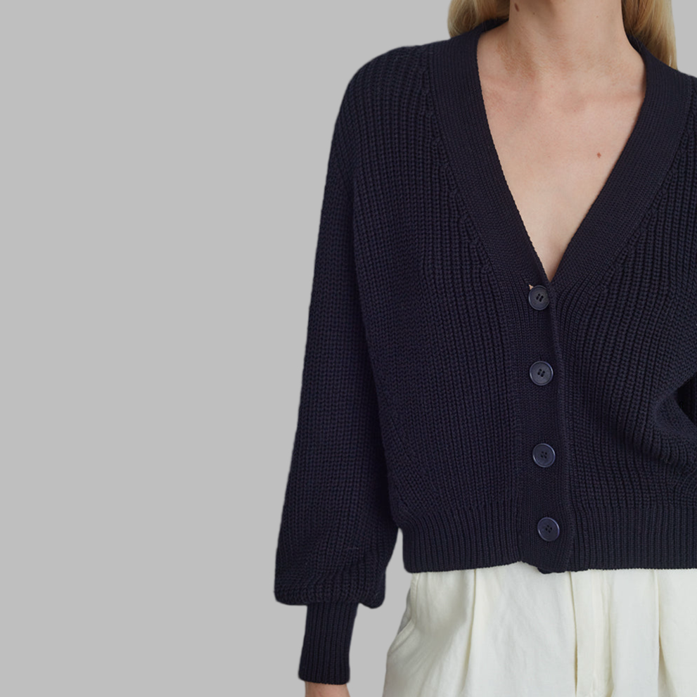 Navy blue cardigan worn by a person on a plain background