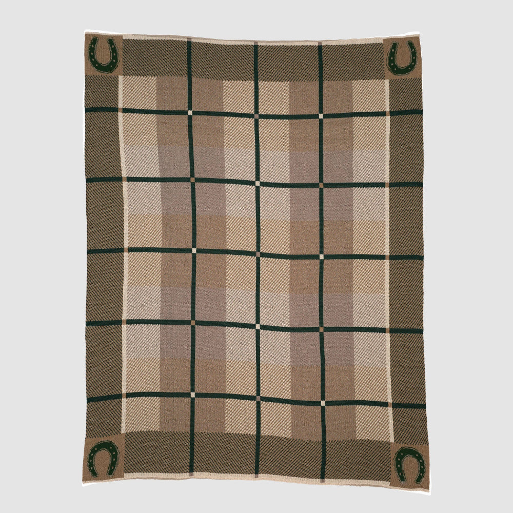 Plaid blanket with green horseshoe patterns on a light gray background