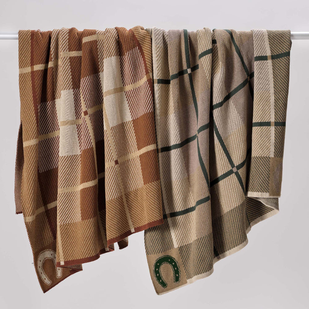 Two plaid blankets with a horse shoe design on a white background