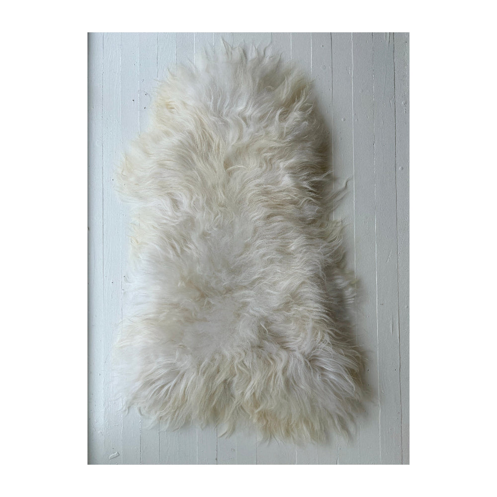 White sheepskin rug on a light wooden floor