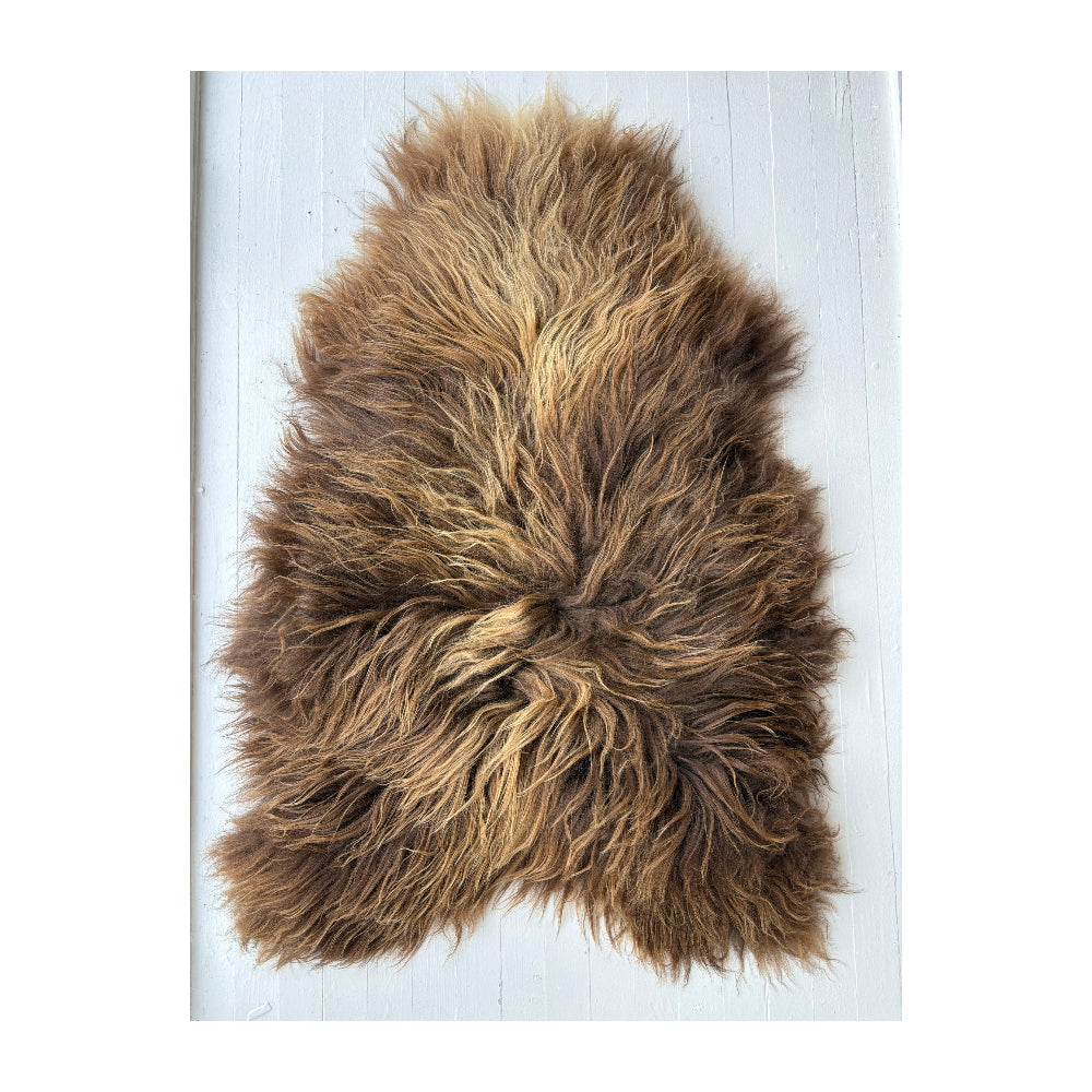 Brown sheepskin rug on a white background