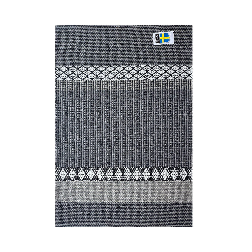 Gray patterned rug with a small flag label on a white background