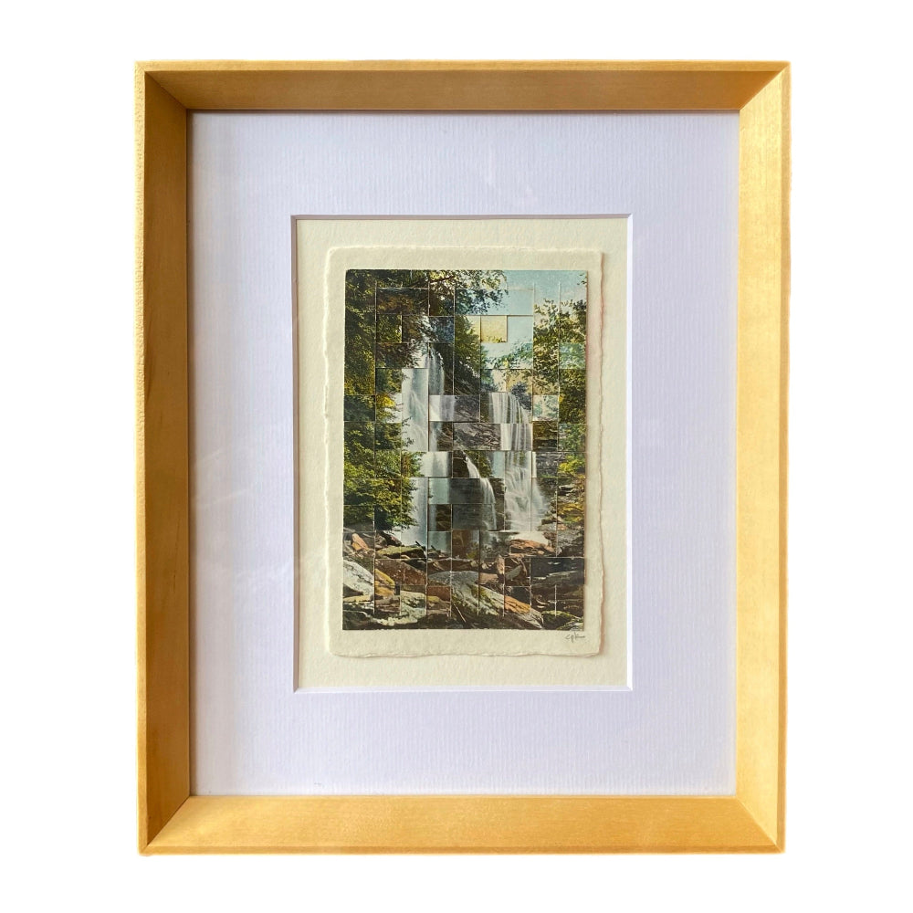 Framed artwork of a waterfall with a gold frame on a white background