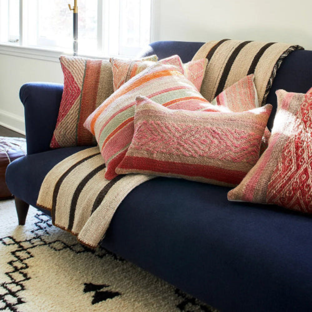 Navy blue sofa with colorful patterned cushions in a living room setting.