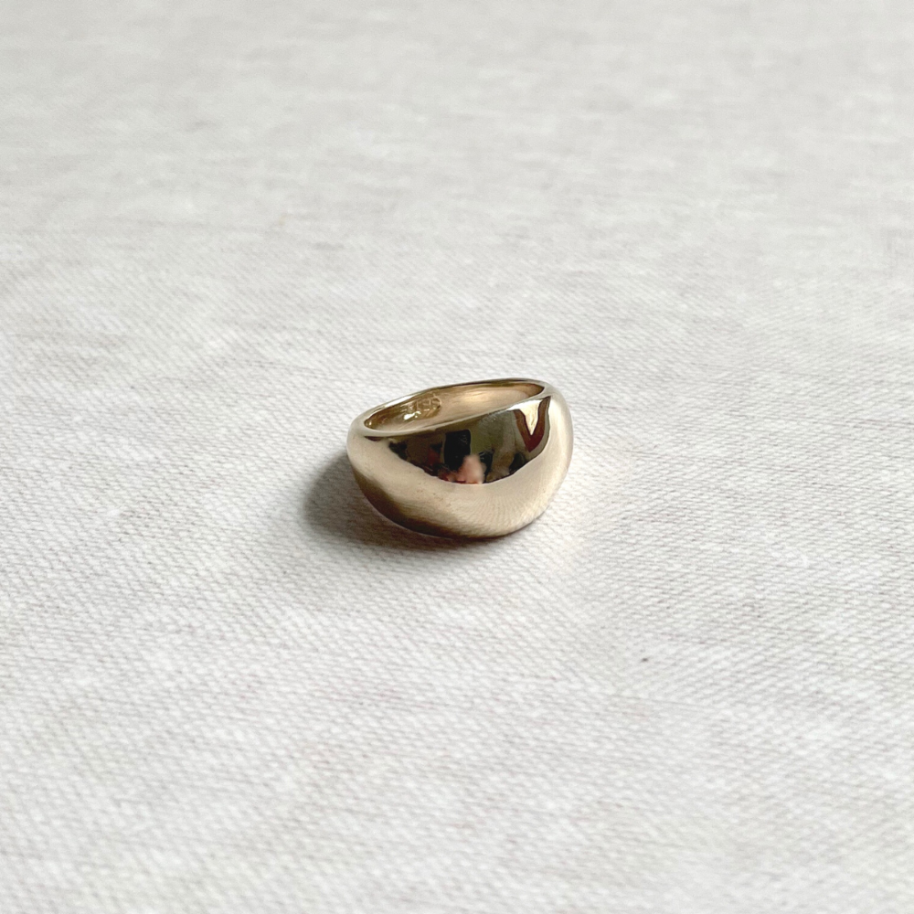 Brass ring on a textured white fabric background