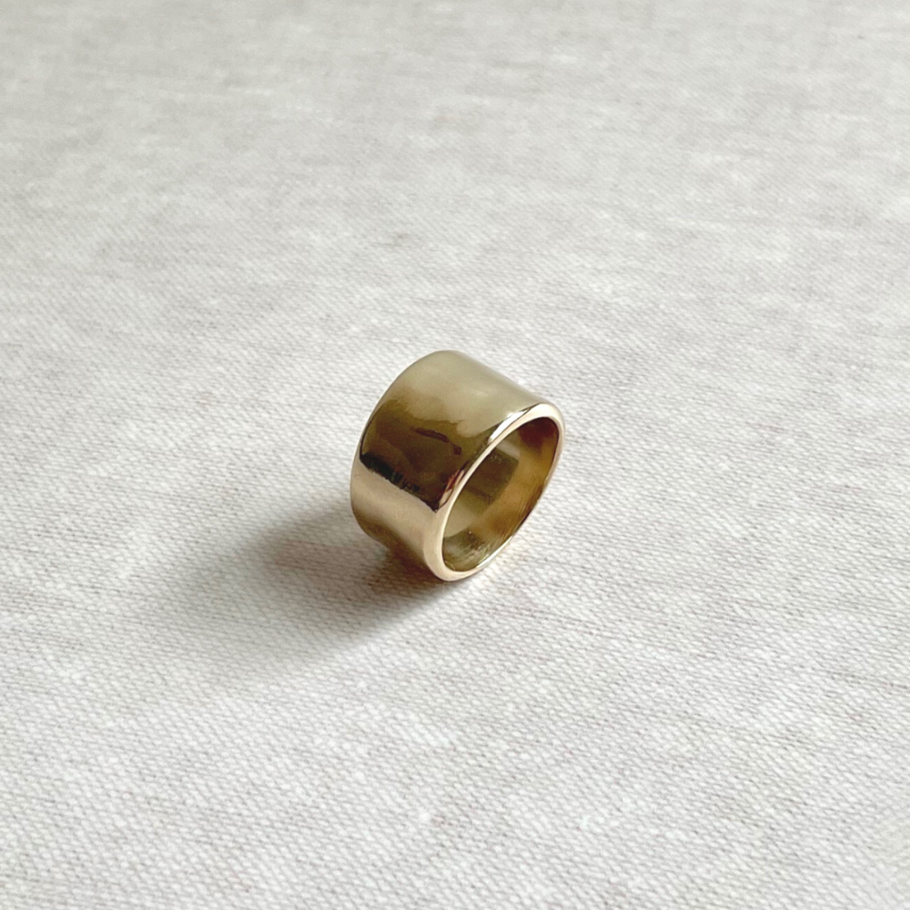 Brass ring on a textured white fabric background