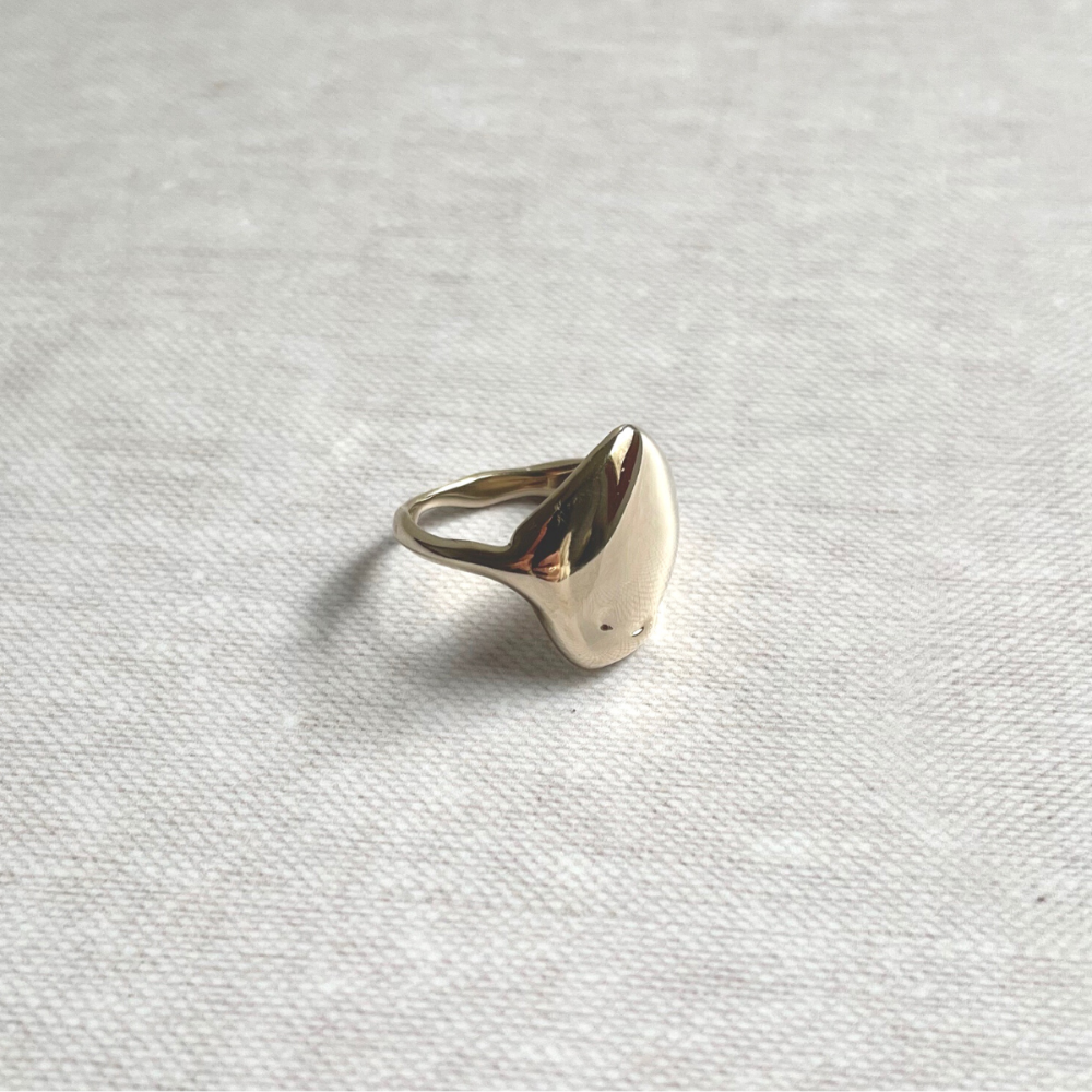 Brass ring on a light gray textured fabric background
