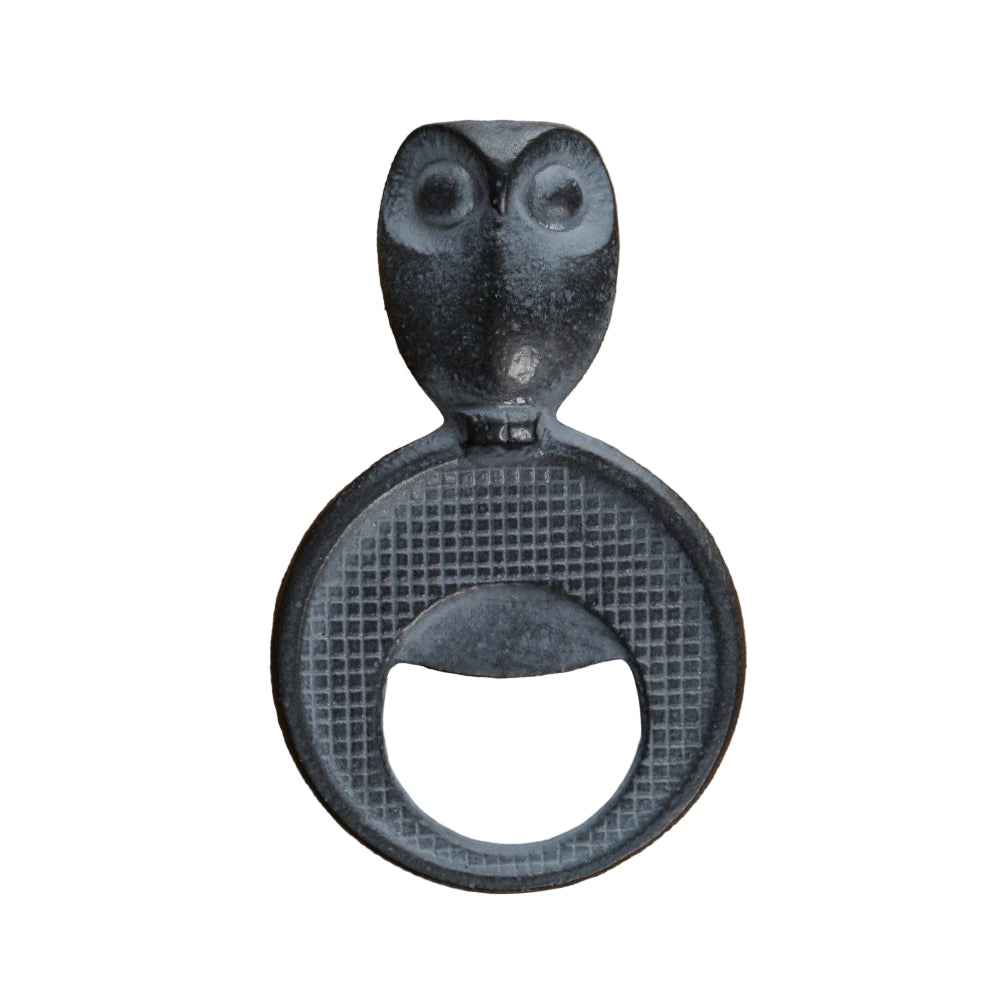 Decorative bottle opener with owl design on a brown fabric background