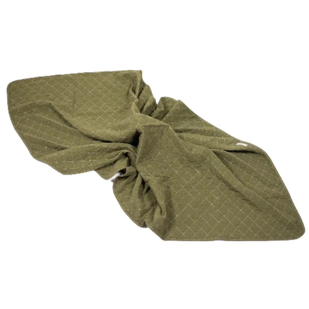 Green quilted blanket bunched up on a white background