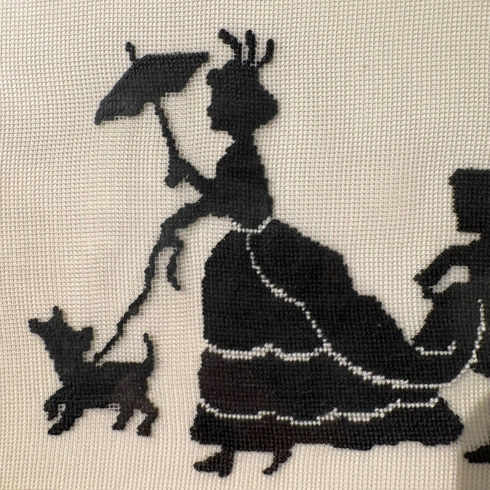 Silhouette of a woman with a dog needlepoint