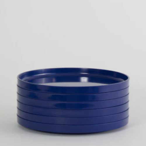 Stacked blue ceramic dinner plates on a neutral background.