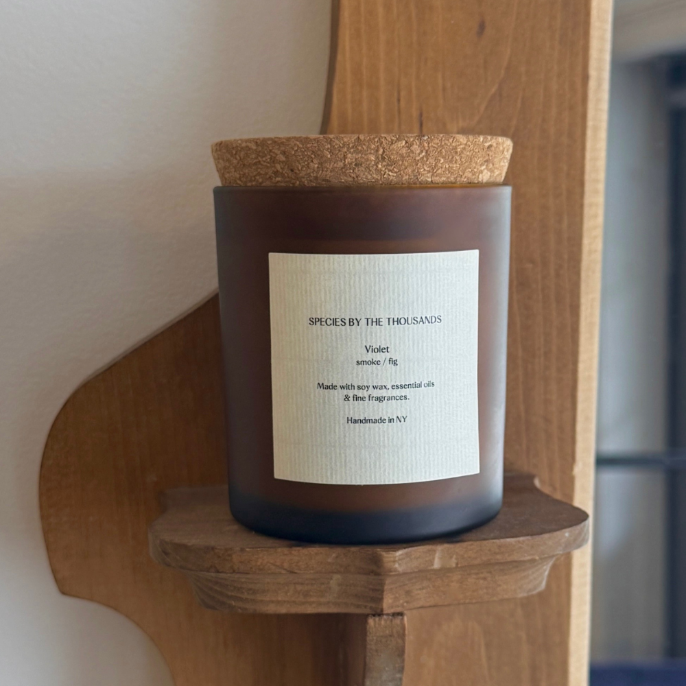 Candle with cork lid on a wooden shelf