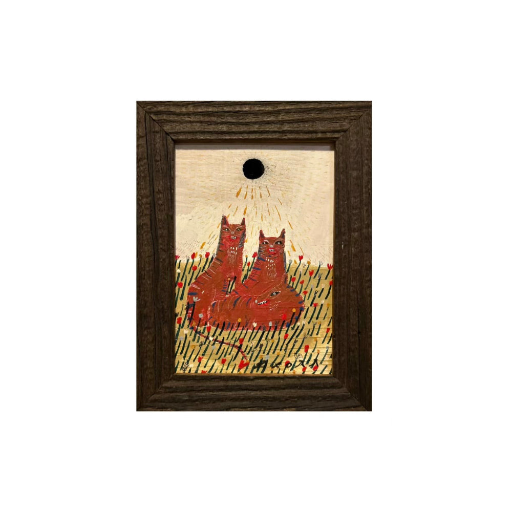 A framed folk art print featuring two red boots in a field under a black sun on a cream background, enclosed in a dark brown wooden frame.